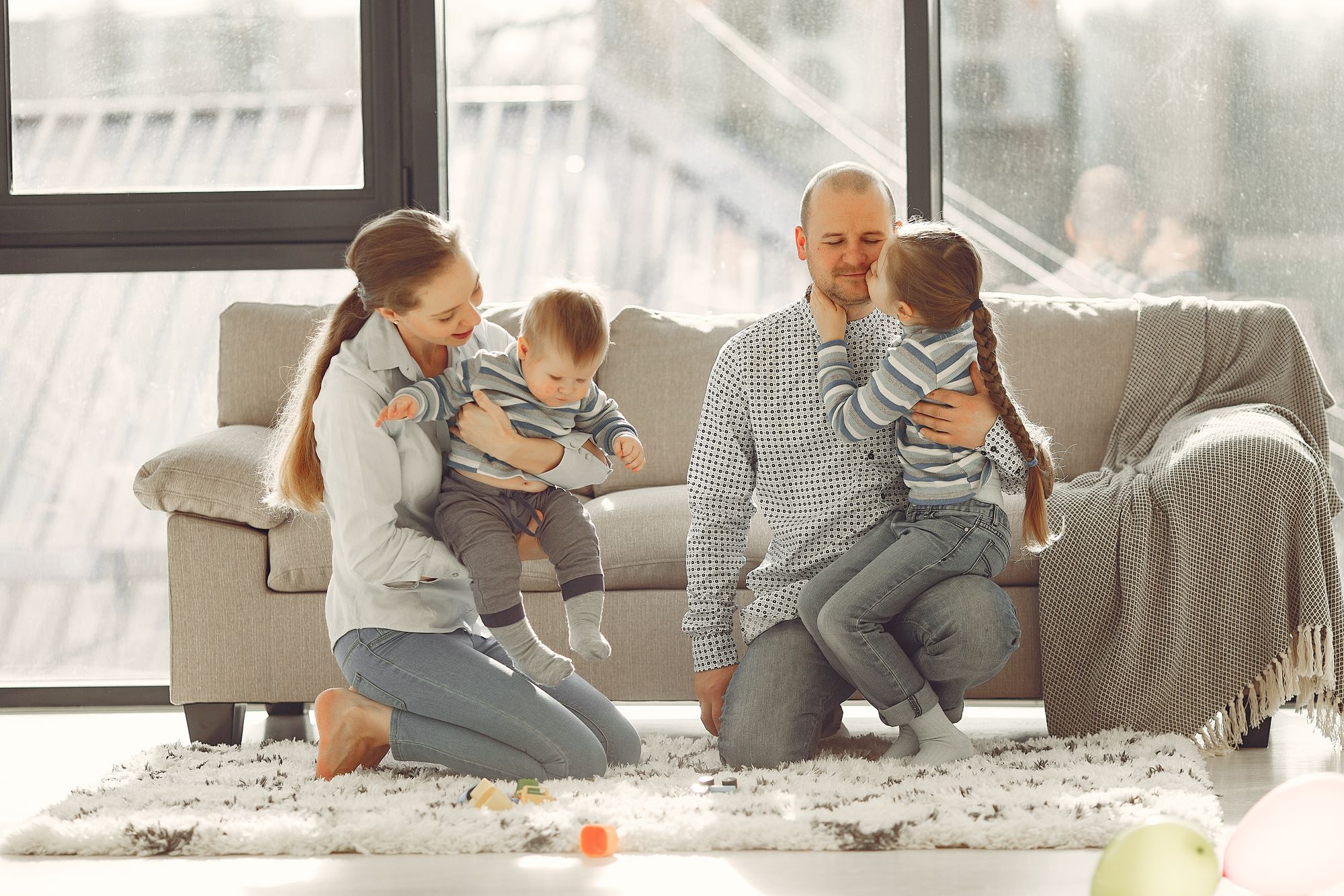 Parents laughing and playing with their children at home